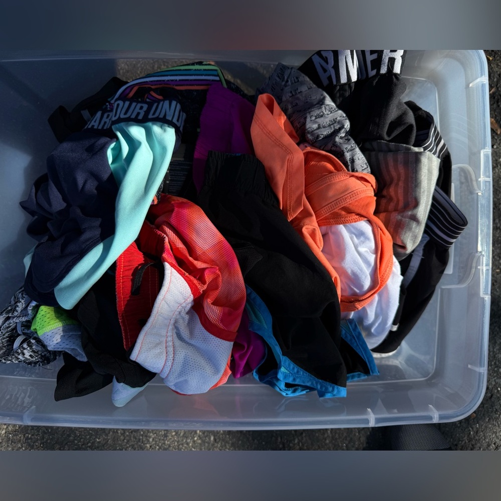 Box of women’s medium running shorts and tank tops